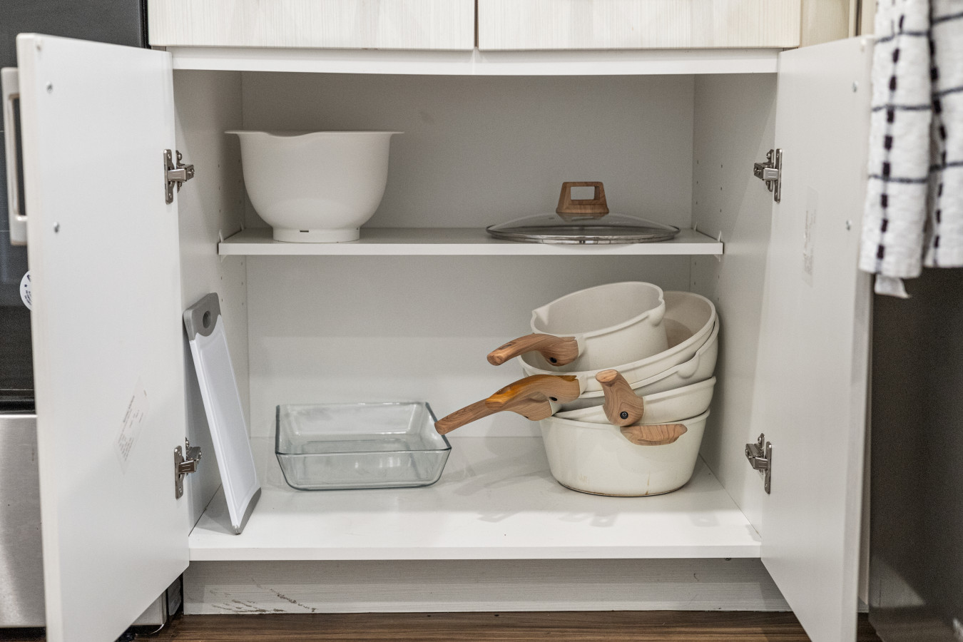 Well-stocked kitchen cabinets with quality cookware and essentials, thoughtfully organized for your convenience.
