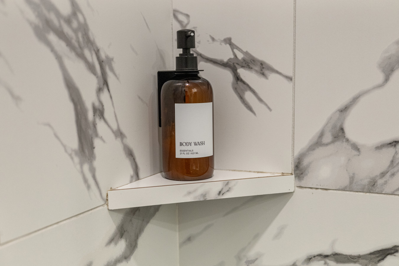 Modern convenience: Premium body wash provided in a stylish, marble-tiled shower.