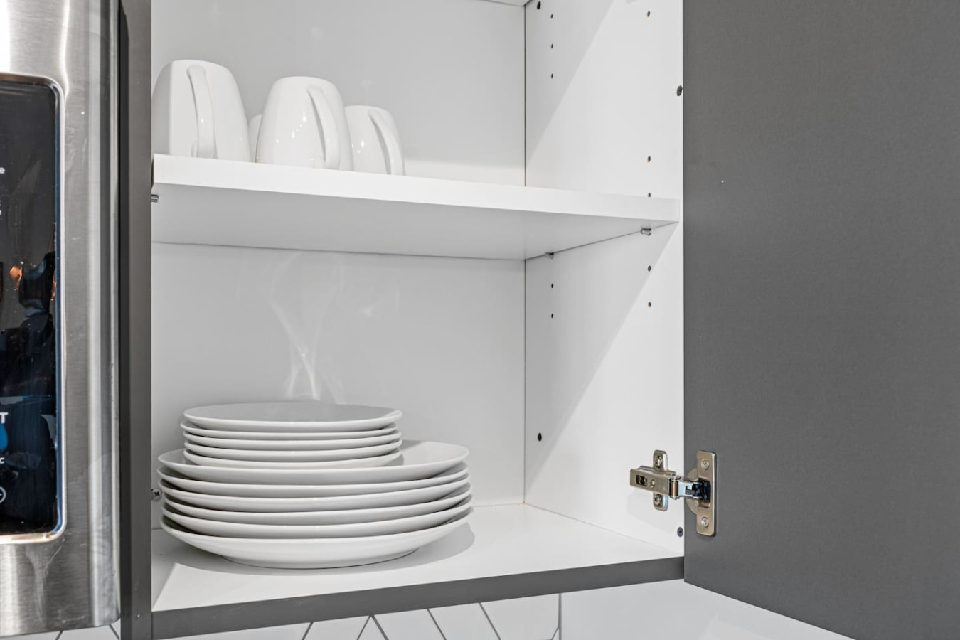 Kitchen cabinets stocked with cooking wares, glassware and silverwares, ideal for mixing up your favorite meals and drinks during your stay.