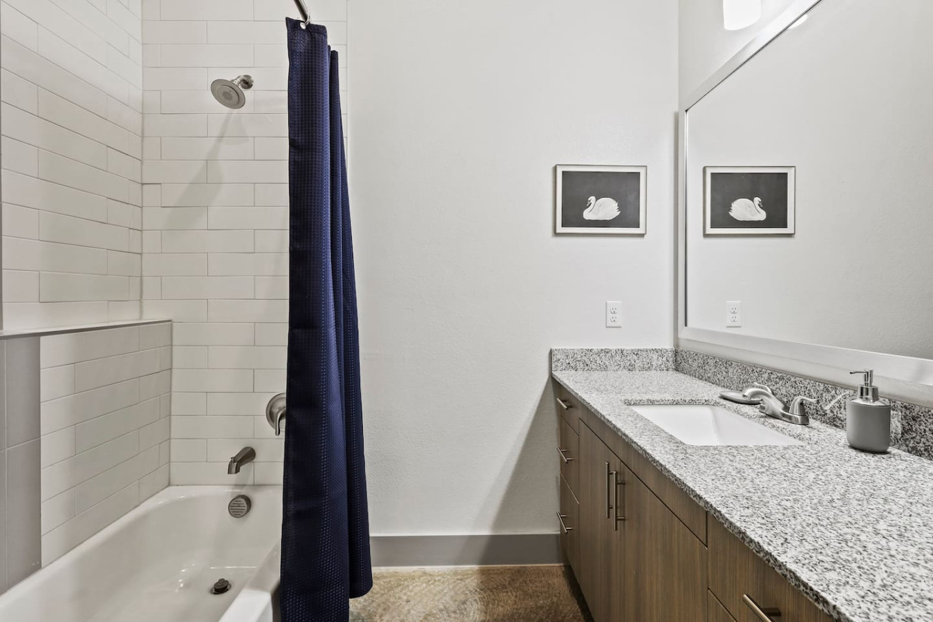 This bright and welcoming bathroom invites you to freshen up in comfort. Enjoy the forest-inspired shower curtain that adds a calming touch to your routine, complemented by the cozy rug underfoot and sparkling clean fixtures.