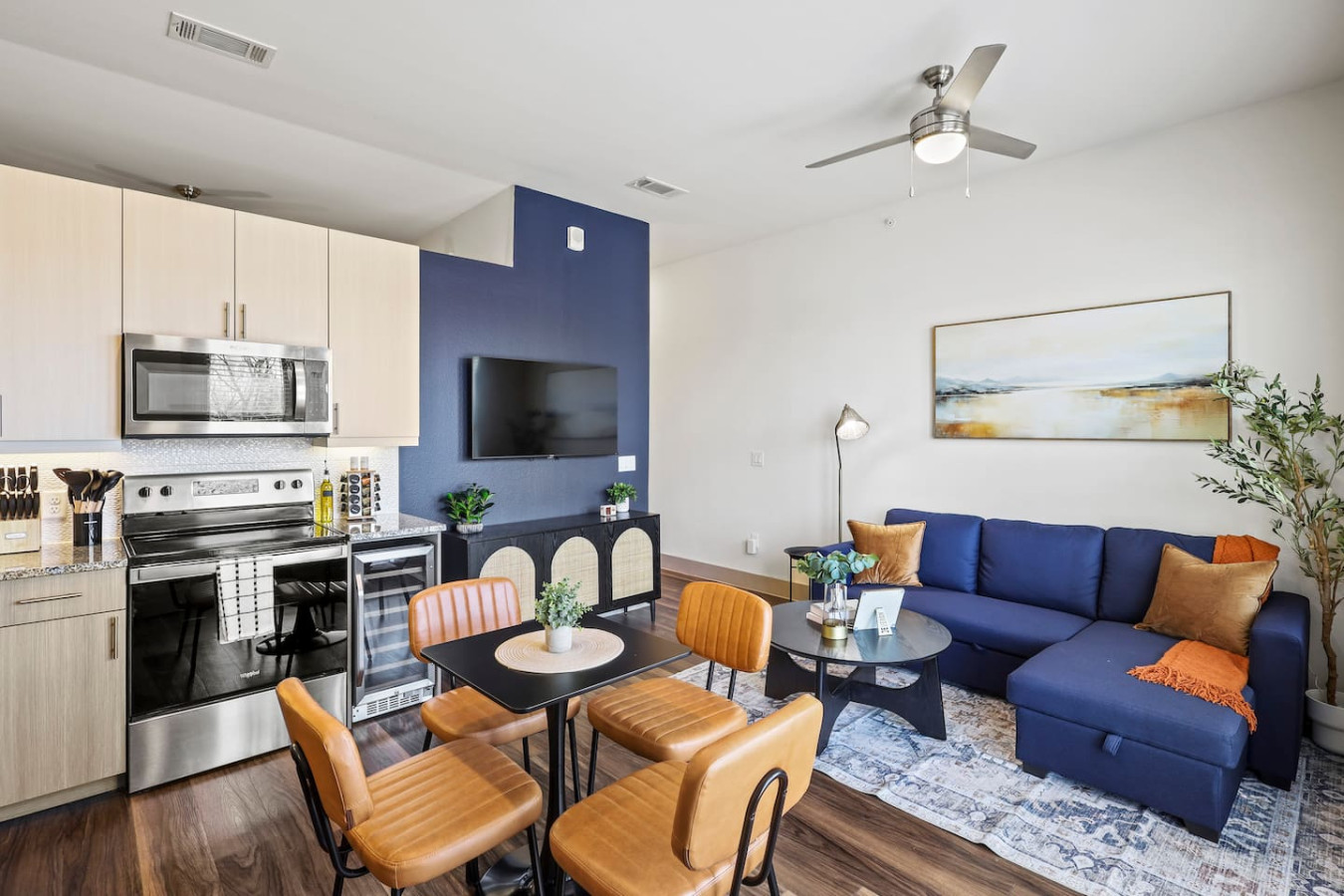 Spacious open-concept living and dining area featuring a vibrant sofa, modern furnishings, and a stylish entertainment setup—ideal for gatherings and relaxation.