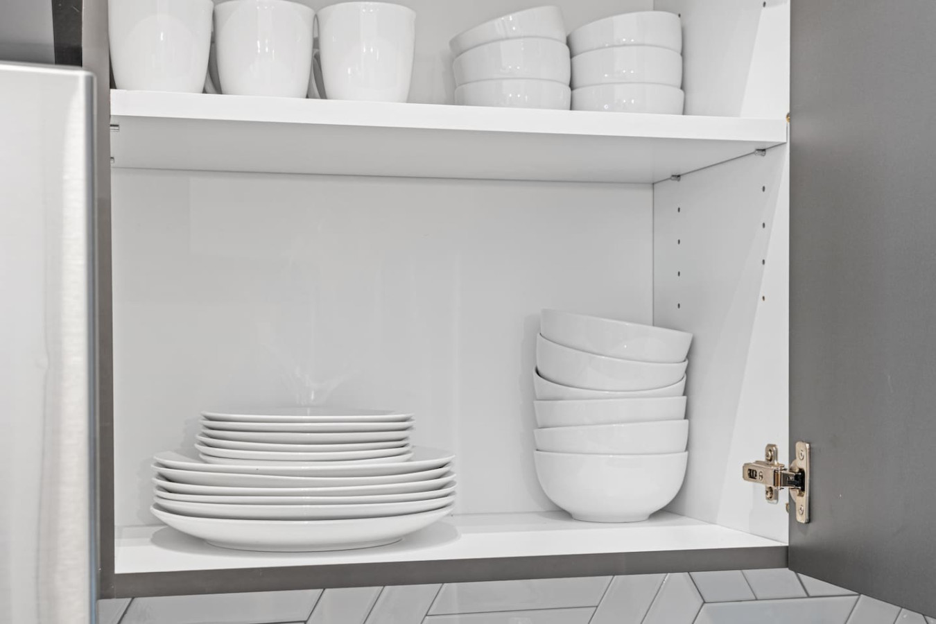 Kitchen cabinets stocked with cooking wares, glassware and silverwares, ideal for mixing up your favorite meals and drinks during your stay.