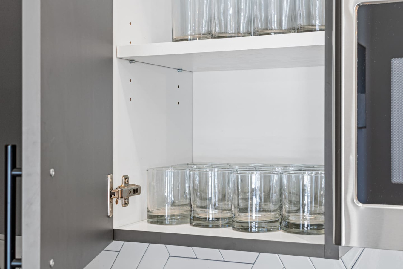 Kitchen cabinets stocked with cooking wares, glassware and silverwares, ideal for mixing up your favorite meals and drinks during your stay.