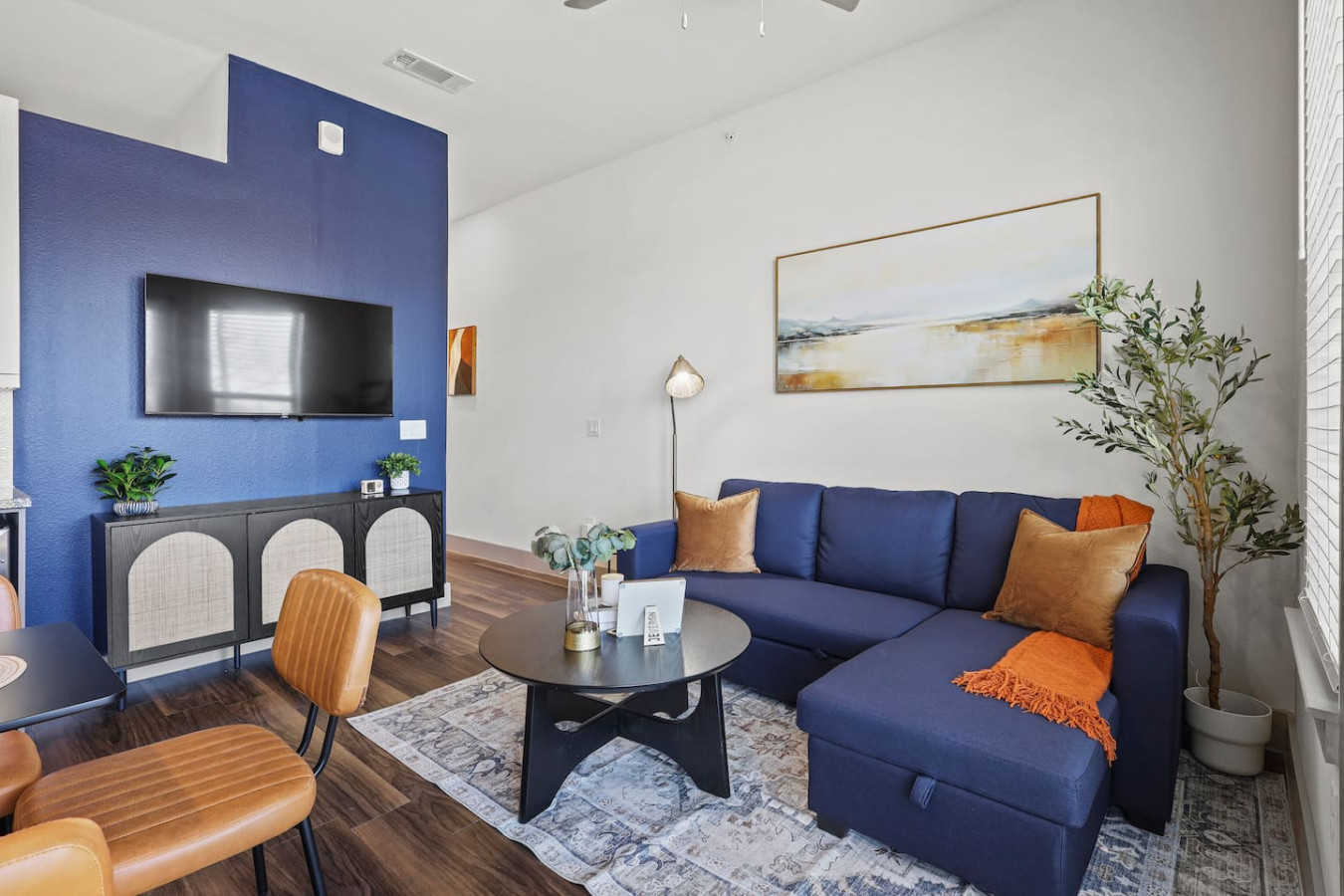 The living room’s plush seating beckons you to sink in and relax, surrounded by light and airy decor.