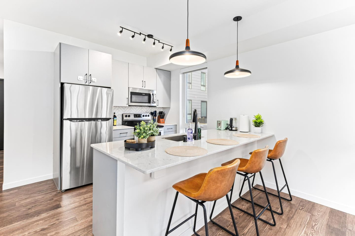 You imagine yourself mixing a cocktail at the stylish home bar, surrounded by a space that’s perfect for socializing.