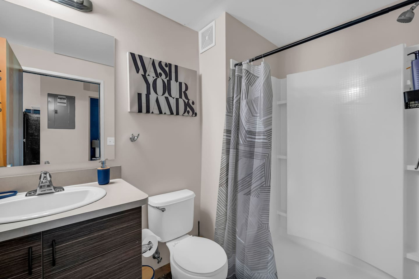 This bright and welcoming bathroom invites you to freshen up in comfort. Enjoy the forest-inspired shower curtain that adds a calming touch to your routine, complemented by the cozy rug underfoot and sparkling clean fixtures.