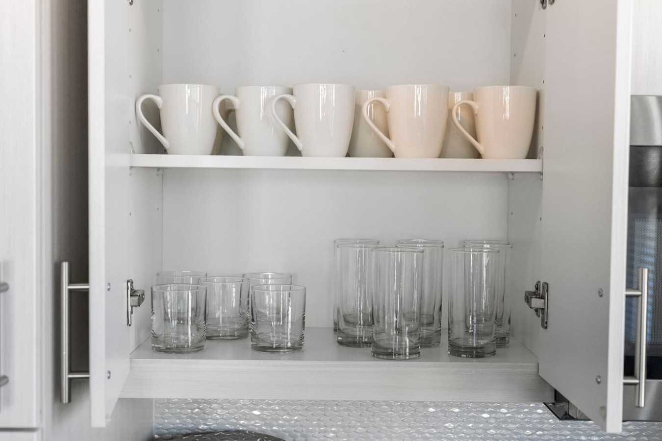 Kitchen cabinets stocked with cooking wares, glassware and silverwares, ideal for mixing up your favorite meals and drinks during your stay.