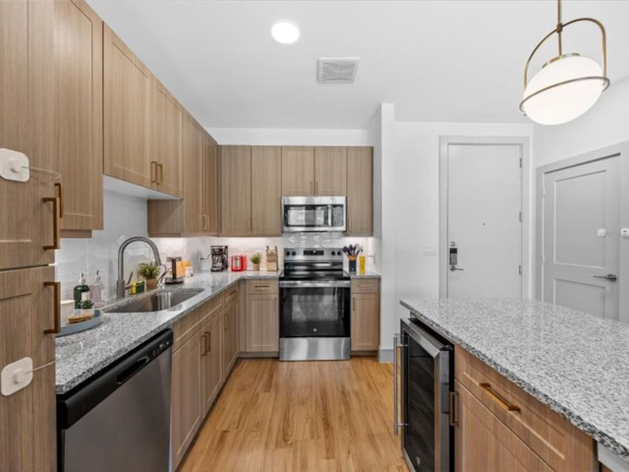 Cook with ease in this well-equipped kitchen featuring stainless steel appliances, ample cabinetry, and a stylish backsplash. Whether you're brewing coffee or preparing a gourmet meal, this space is designed for functionality and style, making every meal