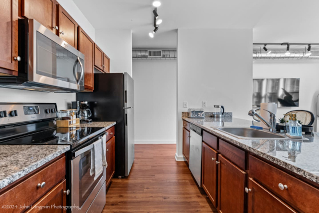 This contemporary kitchen is a chef's dream, featuring a large island, modern stainless steel appliances, and sleek cabinetry. The open layout ensures you can cook and entertain effortlessly, making it the perfect space for culinary creativity and so