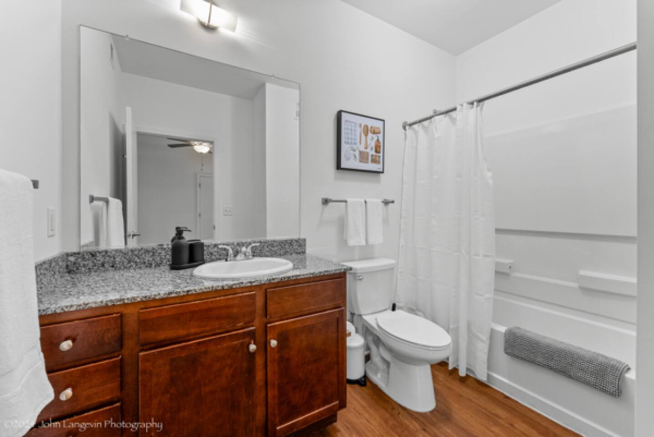Sleek and clean bathroom vanity with modern fixtures, lush greenery, and premium hand soap. Refresh and unwind in style.