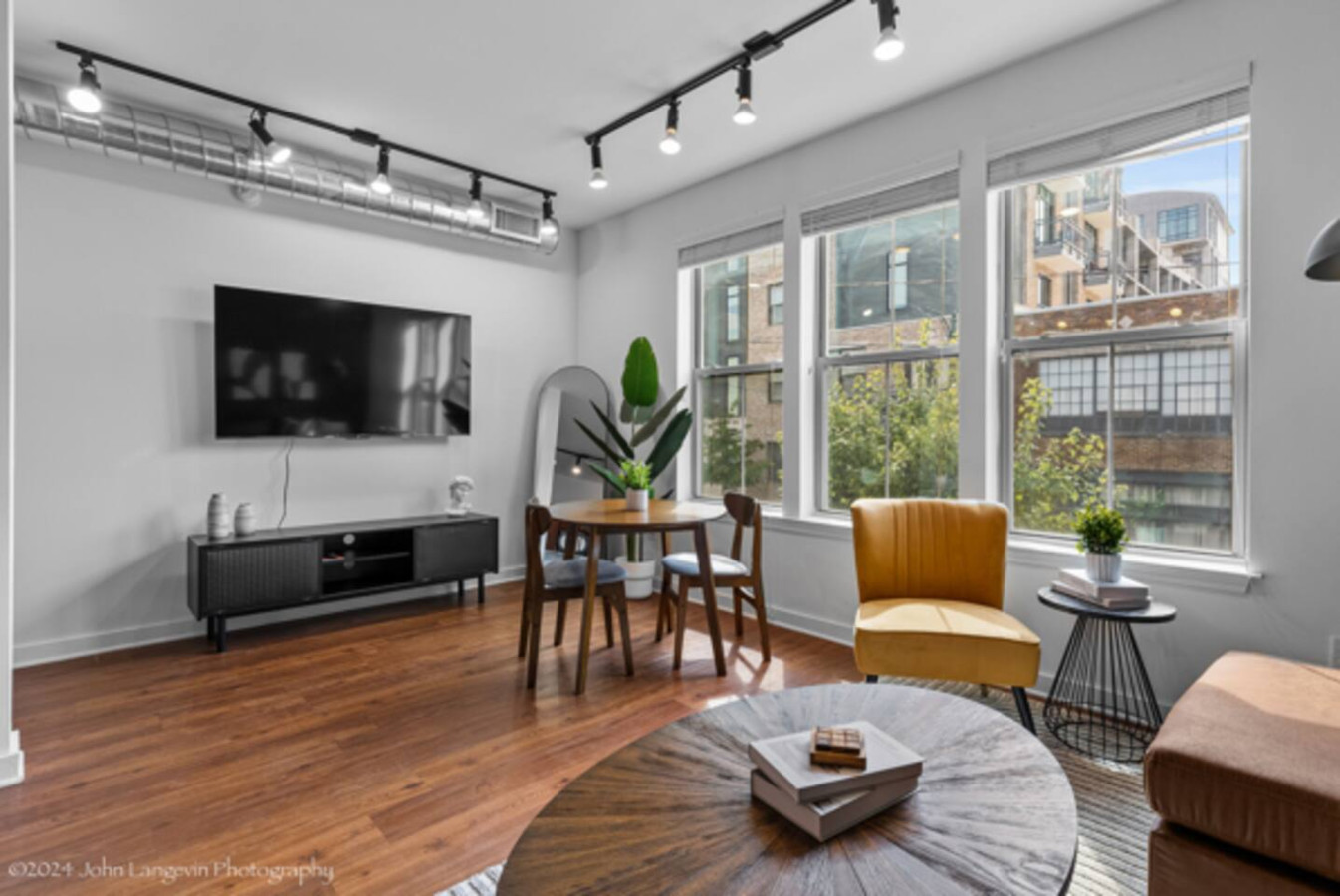 Unwind in the expansive living area with a plush sectional, large TV, and stylish decor. The open layout flows seamlessly to the dining area and balcony, providing ample space for relaxation and entertainment. Perfect for enjoying your stay in comfor