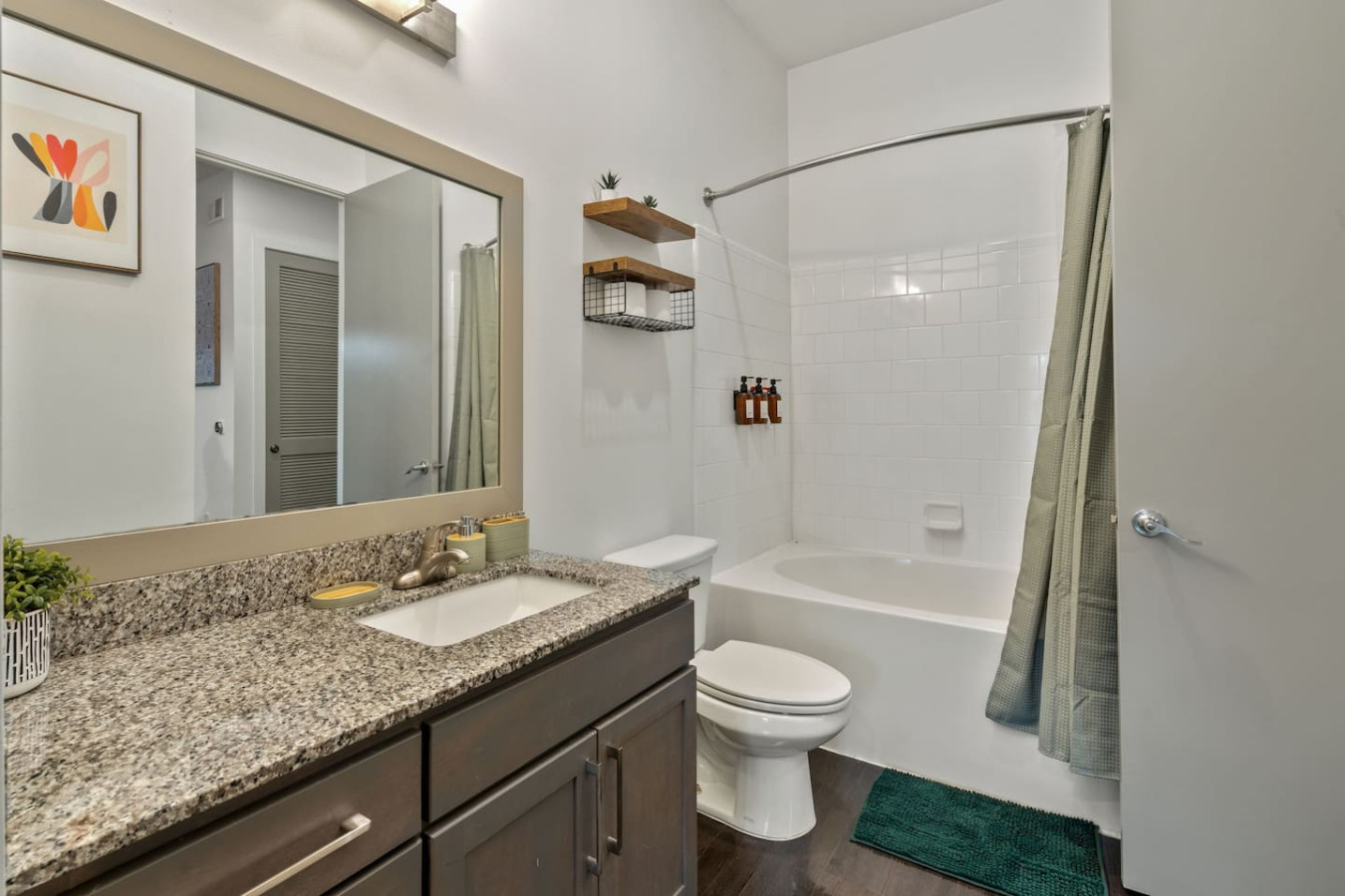 Full bathroom with granite countertops, tub/shower combo with shampoo/conditioner/body wash