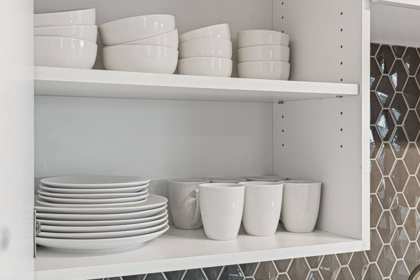 Kitchen cabinets stocked with cooking wares, glassware and silverwares, ideal for mixing up your favorite meals and drinks during your stay.