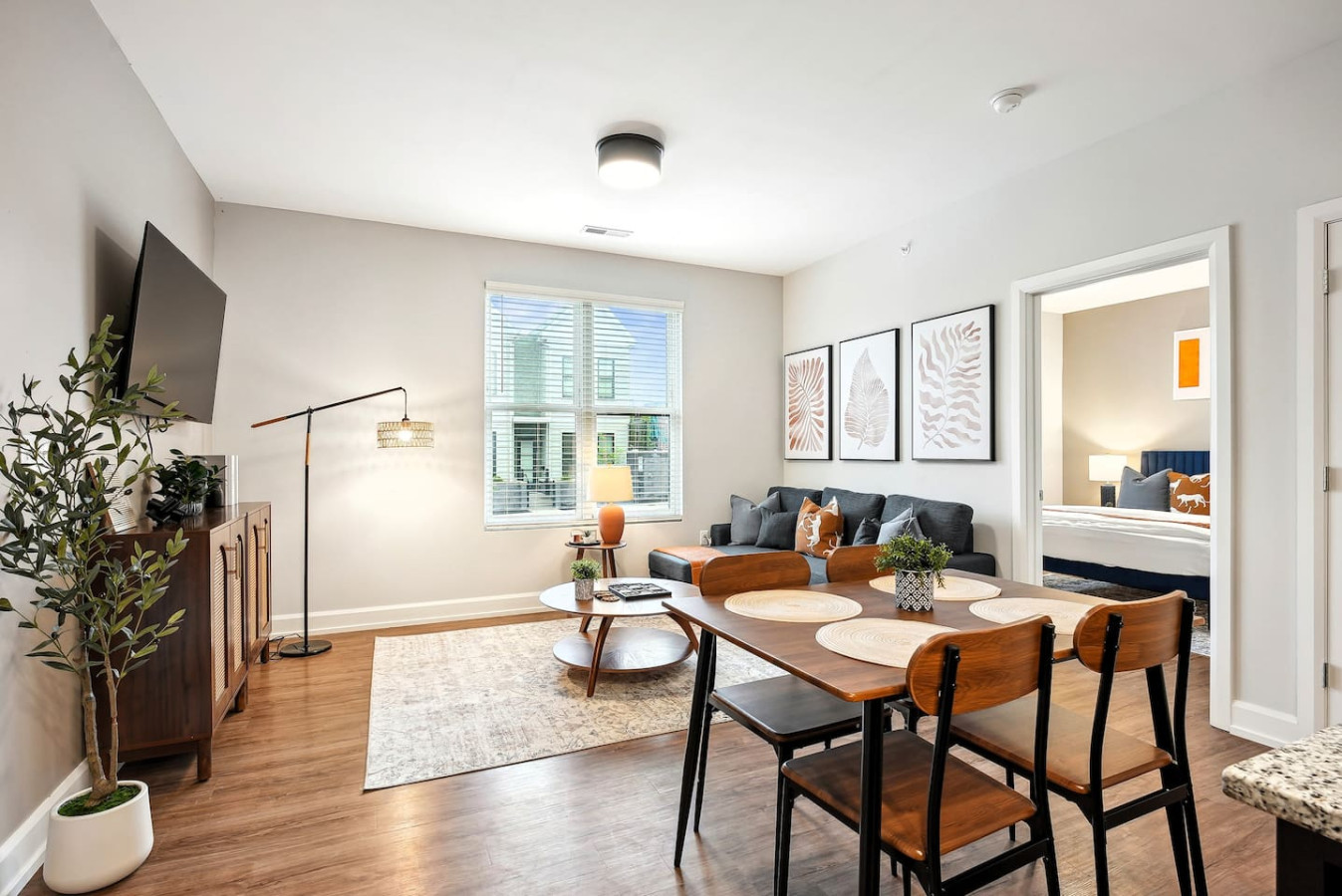 Spacious open-concept living and dining area featuring a vibrant sofa, modern furnishings, and a stylish entertainment setup—ideal for gatherings and relaxation.
