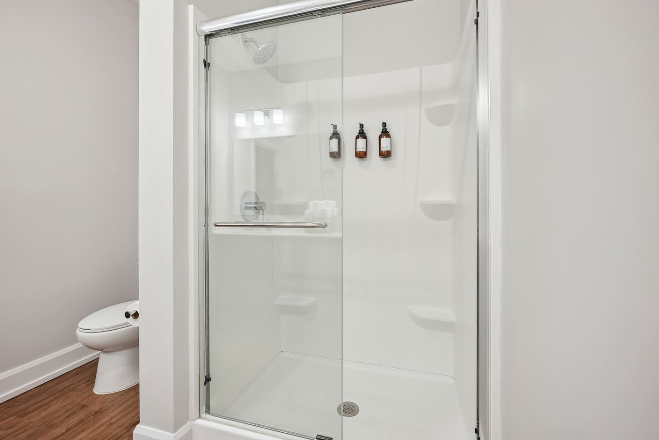 This bright and welcoming bathroom invites you to freshen up in comfort. Enjoy the forest-inspired shower curtain that adds a calming touch to your routine, complemented by the cozy rug underfoot and sparkling clean fixtures.