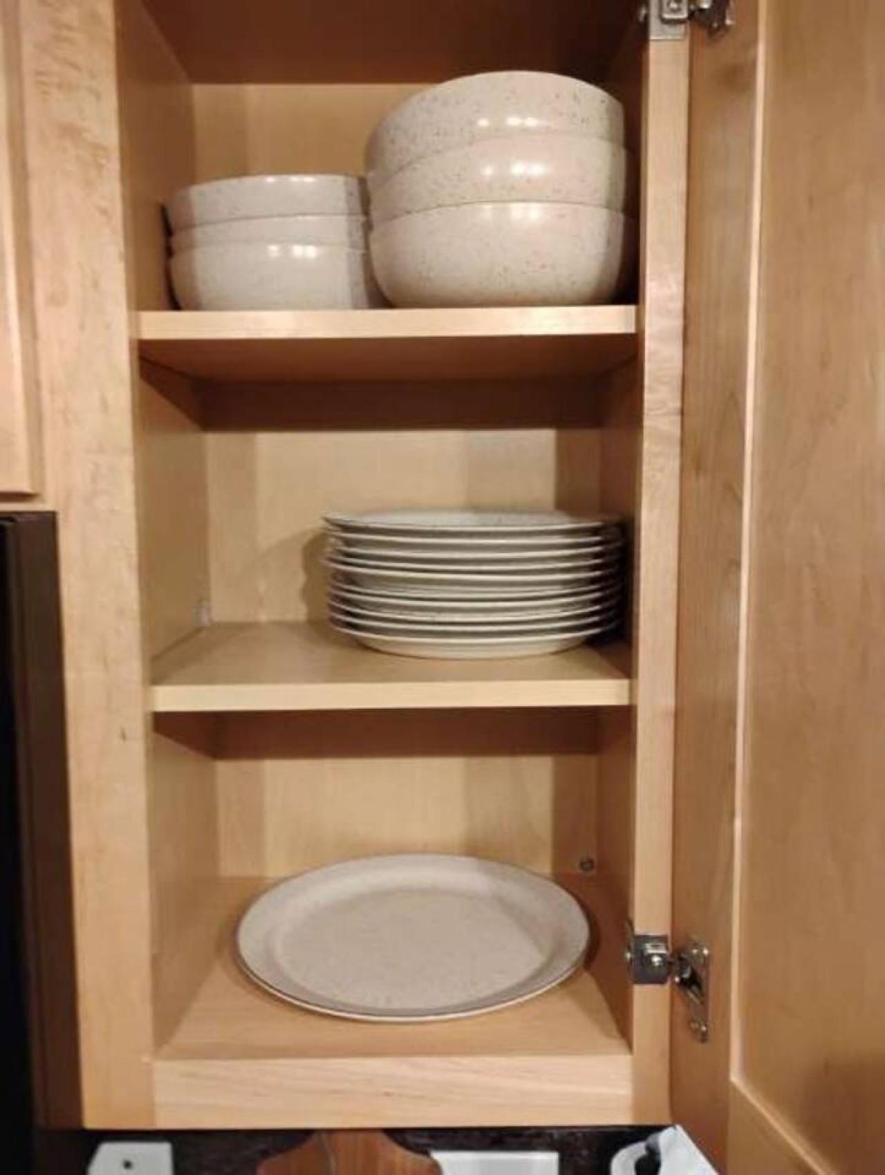 Well-stocked cabinets with plates, bowls, and cookware
