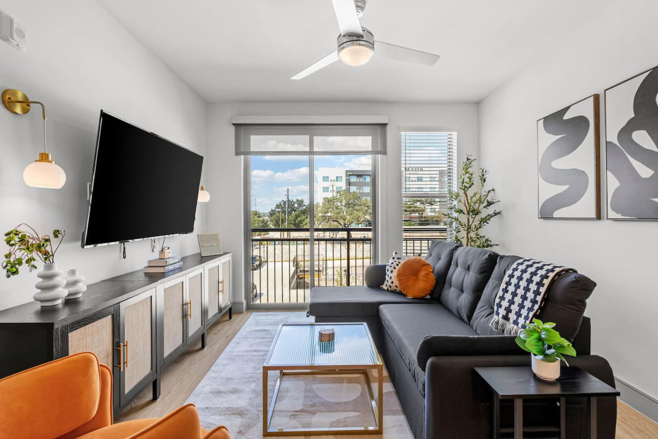 This bright living room combines plush seating, a large TV, and tasteful décor to create a welcoming space for comfort and entertainment.
