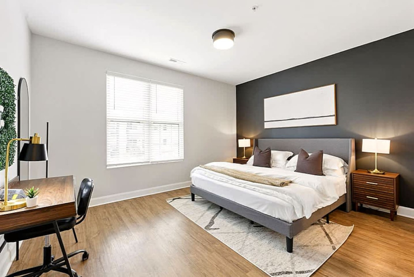 Another view of the bright bedroom showcasing clean lines, modern furnishings, and a comfortable workspace. Ideal for guests needing a quiet, well lit place to unwind or work during their stay.