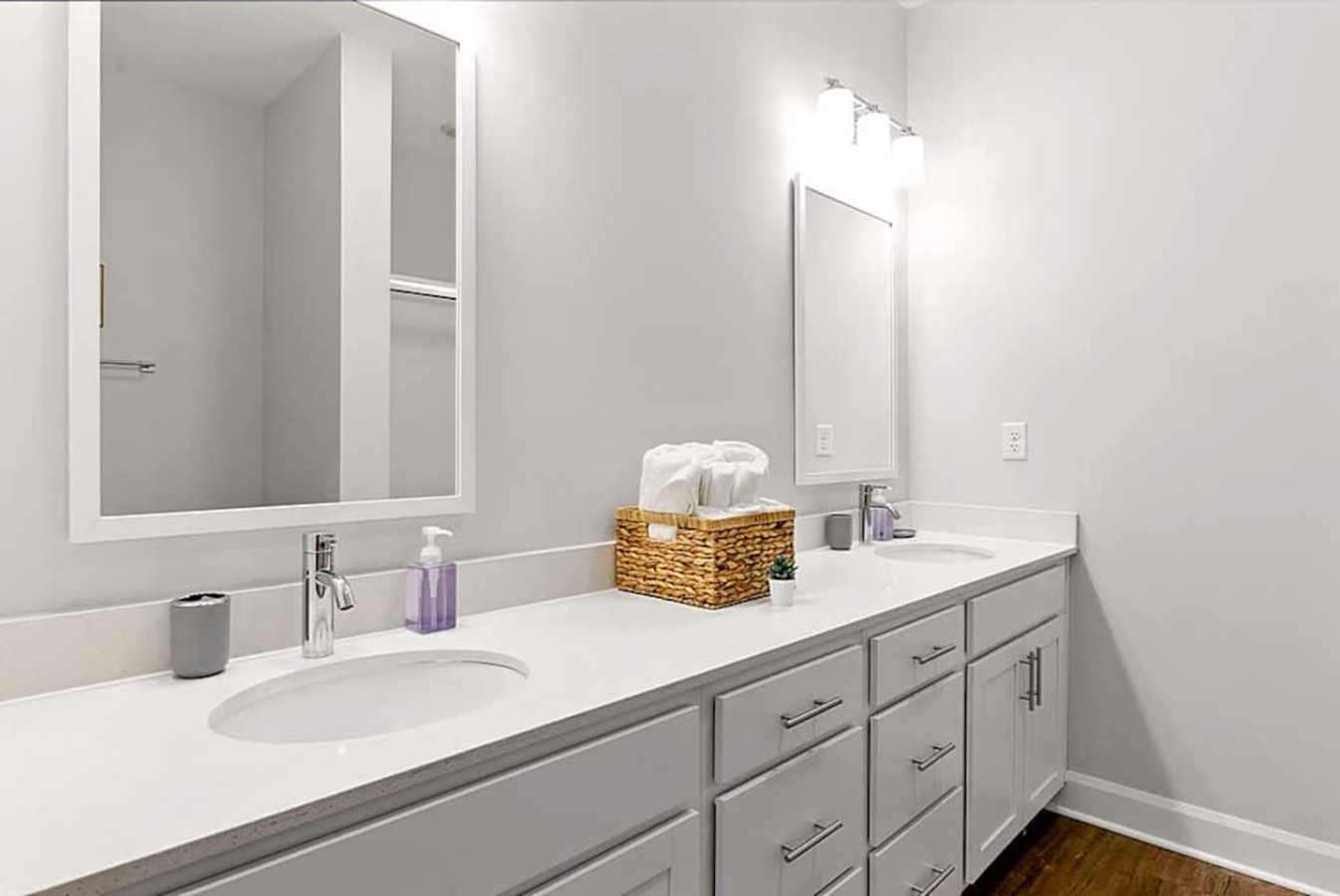 A clean and modern bathroom with dual sinks, generous counter space, and bright lighting. Ideal for guests needing room to prepare for the day, offering a hotel like experience with added convenience and comfort.