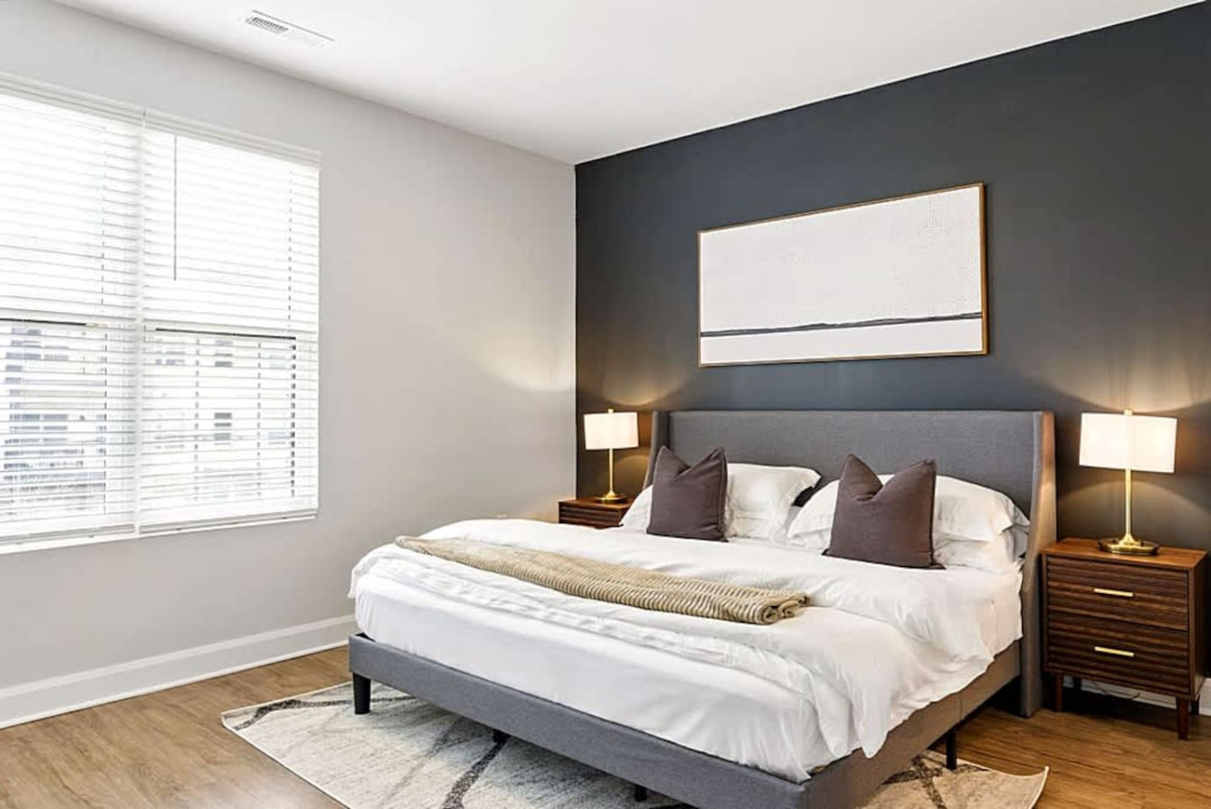 A bright and comfortable bedroom featuring a cozy bed, modern décor, and large windows that fill the space with natural light. Perfect for restful nights and a peaceful retreat during your stay.