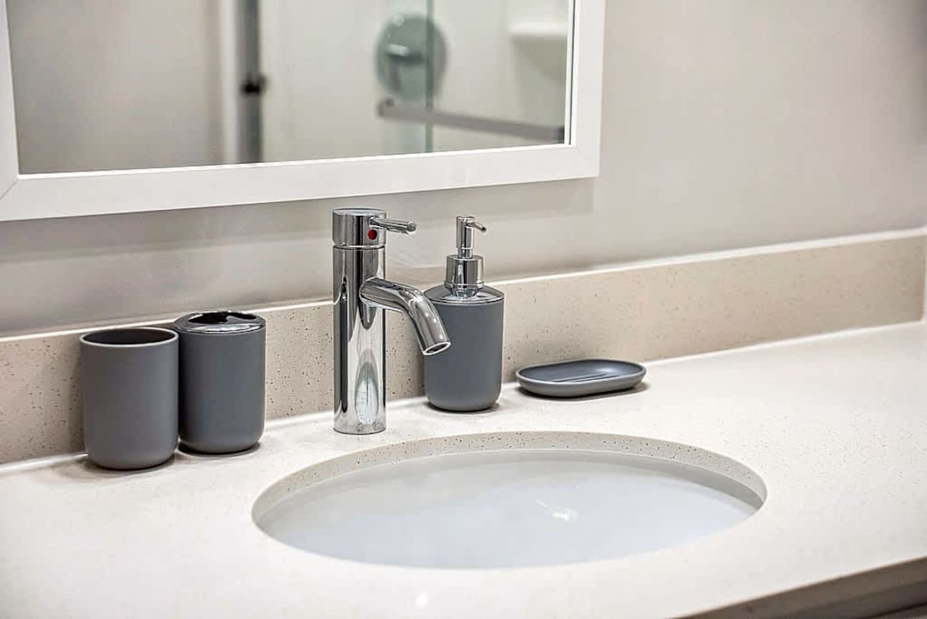 A spotless bathroom vanity with modern fixtures, bright lighting, and convenient storage. Designed to provide guests with the comfort and ease of a well maintained, hotel style bathroom.