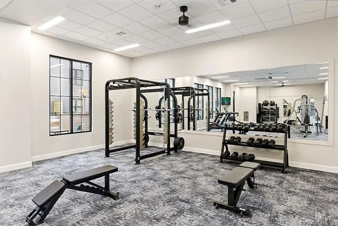 A modern strength training zone featuring racks, benches, and free weights. Designed for both novice and experienced lifters, this space allows guests to maintain their routines comfortably during their stay.