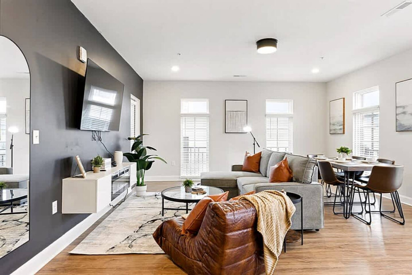 A comfortable living room setup featuring plush seating, a cozy rug, and abundant natural light from surrounding windows. Guests can relax, watch movies, or enjoy peaceful downtime in this thoughtfully arranged space.