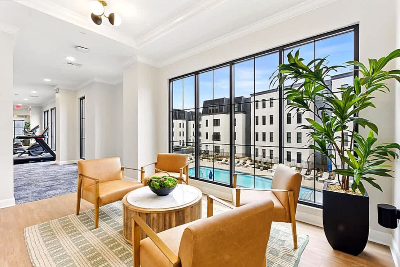 A bright indoor social space with large windows, stylish seating, and views of the community. A great spot to work, relax, or enjoy quiet moments. The modern decor adds comfort and charm to the shared amenities.