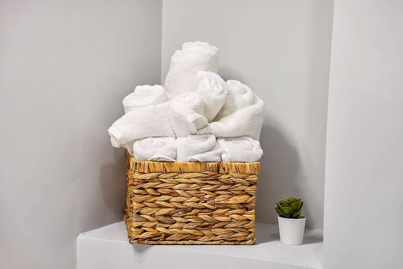 Another view of the bathroom showcasing neatly rolled towels and simple décor accents. The clean and organized setup adds a welcoming touch and enhances the overall guest experience.