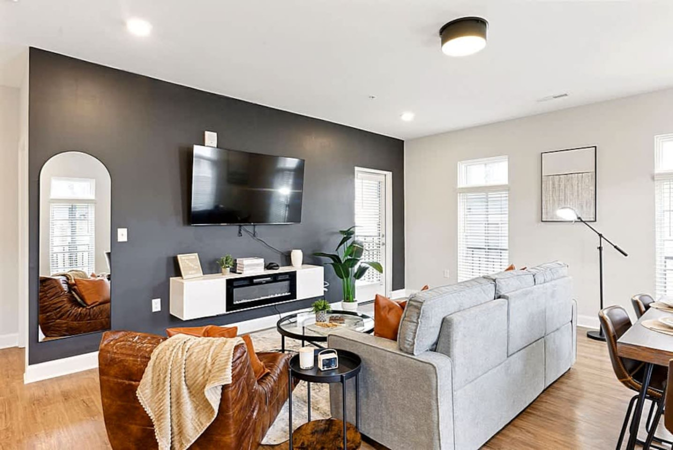 A warm and contemporary living area with a spacious sectional, mounted TV, and modern accents. This bright and open design provides the perfect place to relax after a day of exploring or enjoying the amenities.