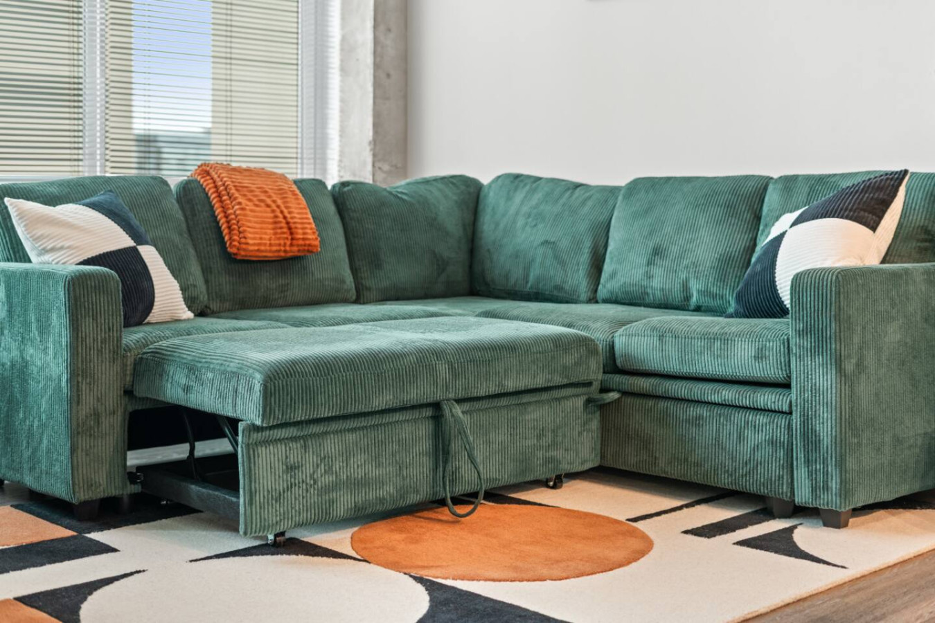 The teal corduroy sectional converts into a sleeper sofa, offering a comfortable extra sleeping space for an additional guest. Plush cushions and cozy throw blankets ensure a restful night in the heart of downtown Atlanta.