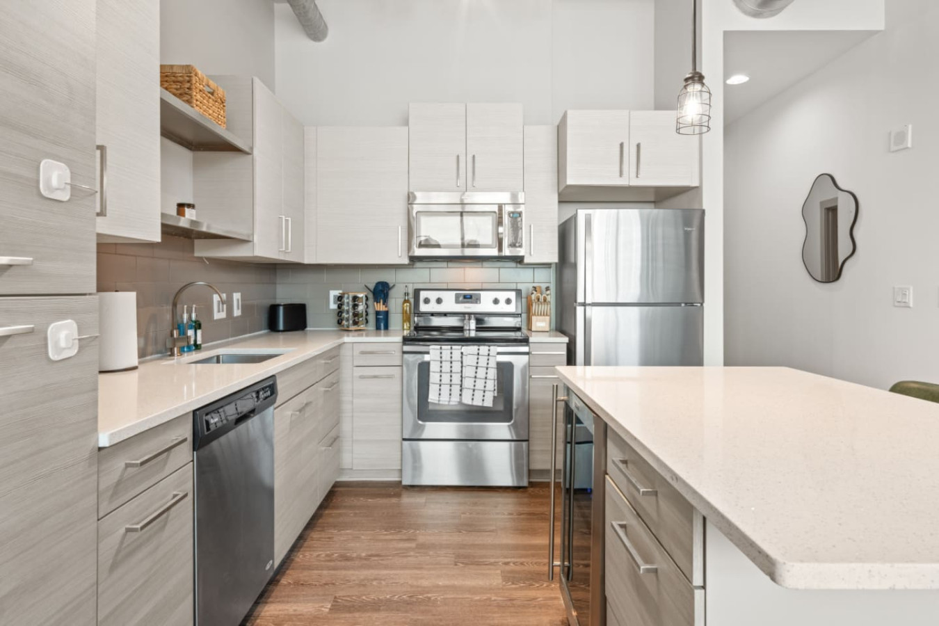 Fully equipped kitchen with stainless steel appliances, dishwasher, oven, microwave, and full-size fridge. Quartz countertops, ample cabinet storage, and a kitchen island make cooking in easy. Stocked with essentials for your stay.