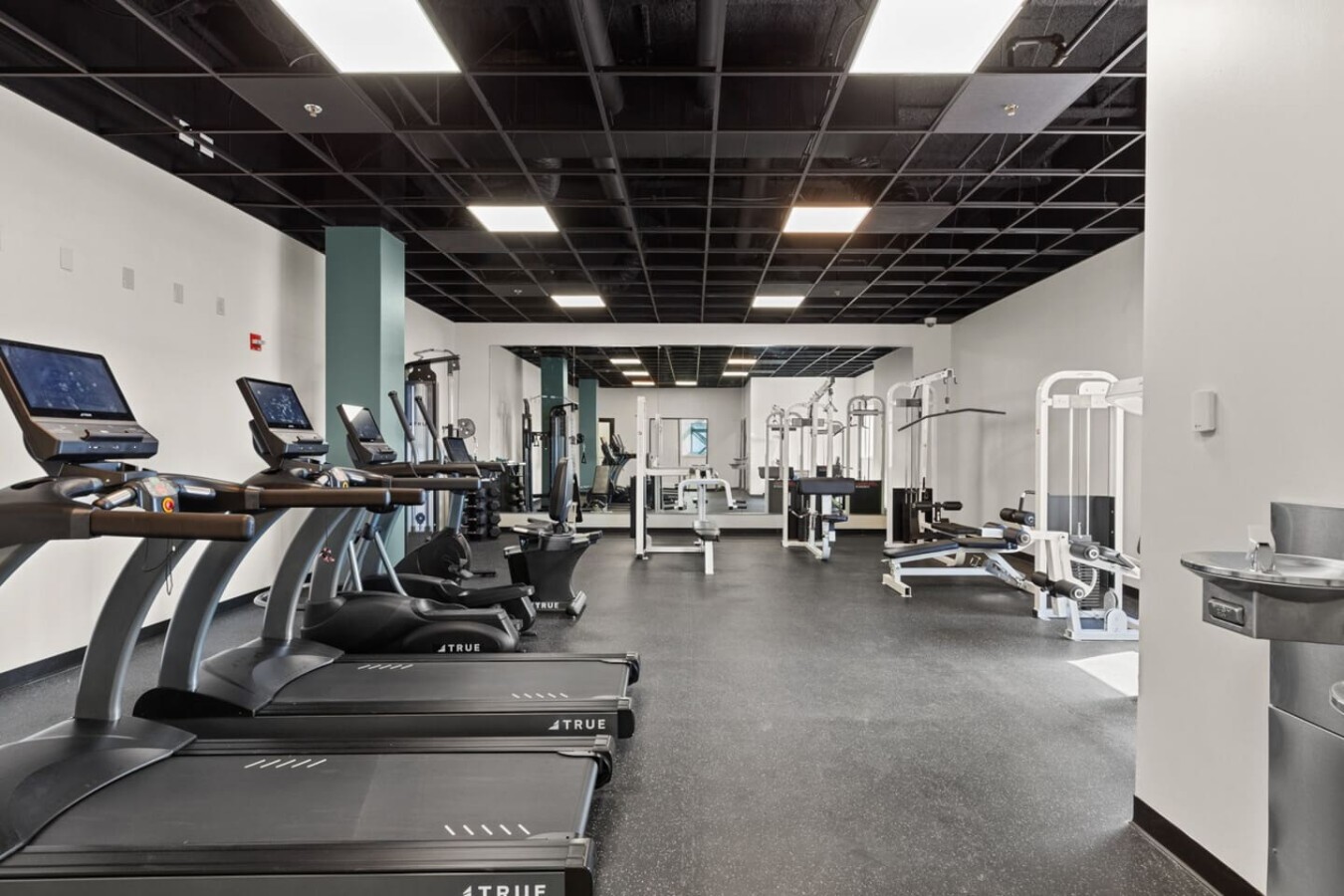 Communal gym with extensive equipment and water fountains.