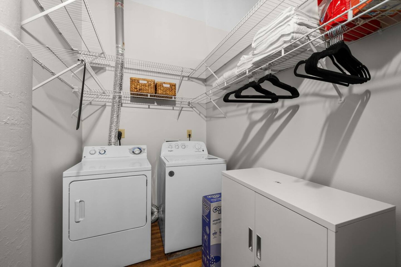 Washer and dryer with additional storage and hanging space.