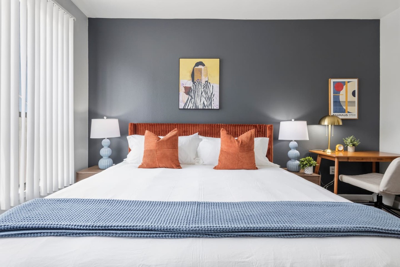 King bedroom with workspace, natural light, and ceiling fan.