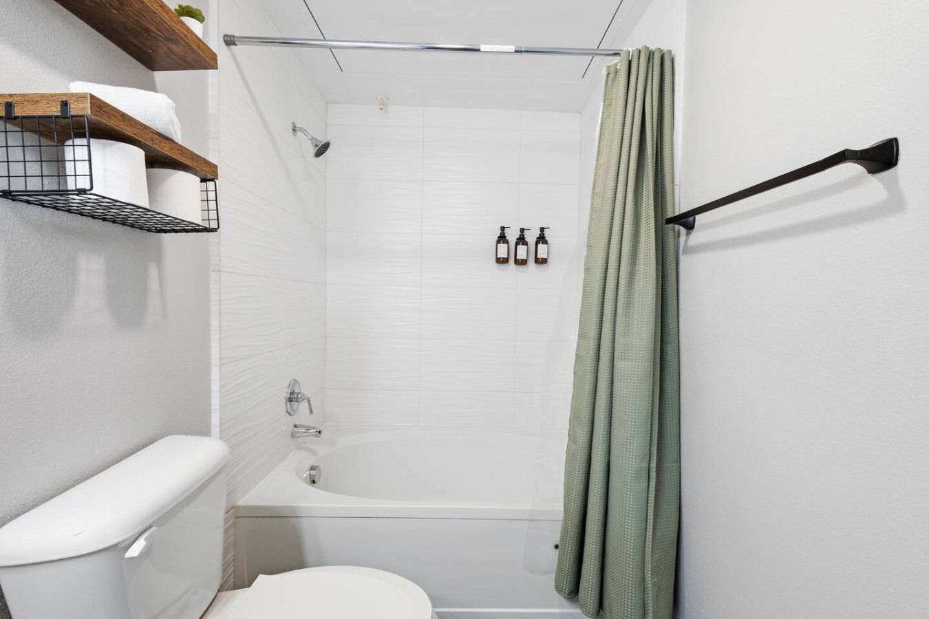 Bathroom with shower, toilet, and neatly arranged towels.