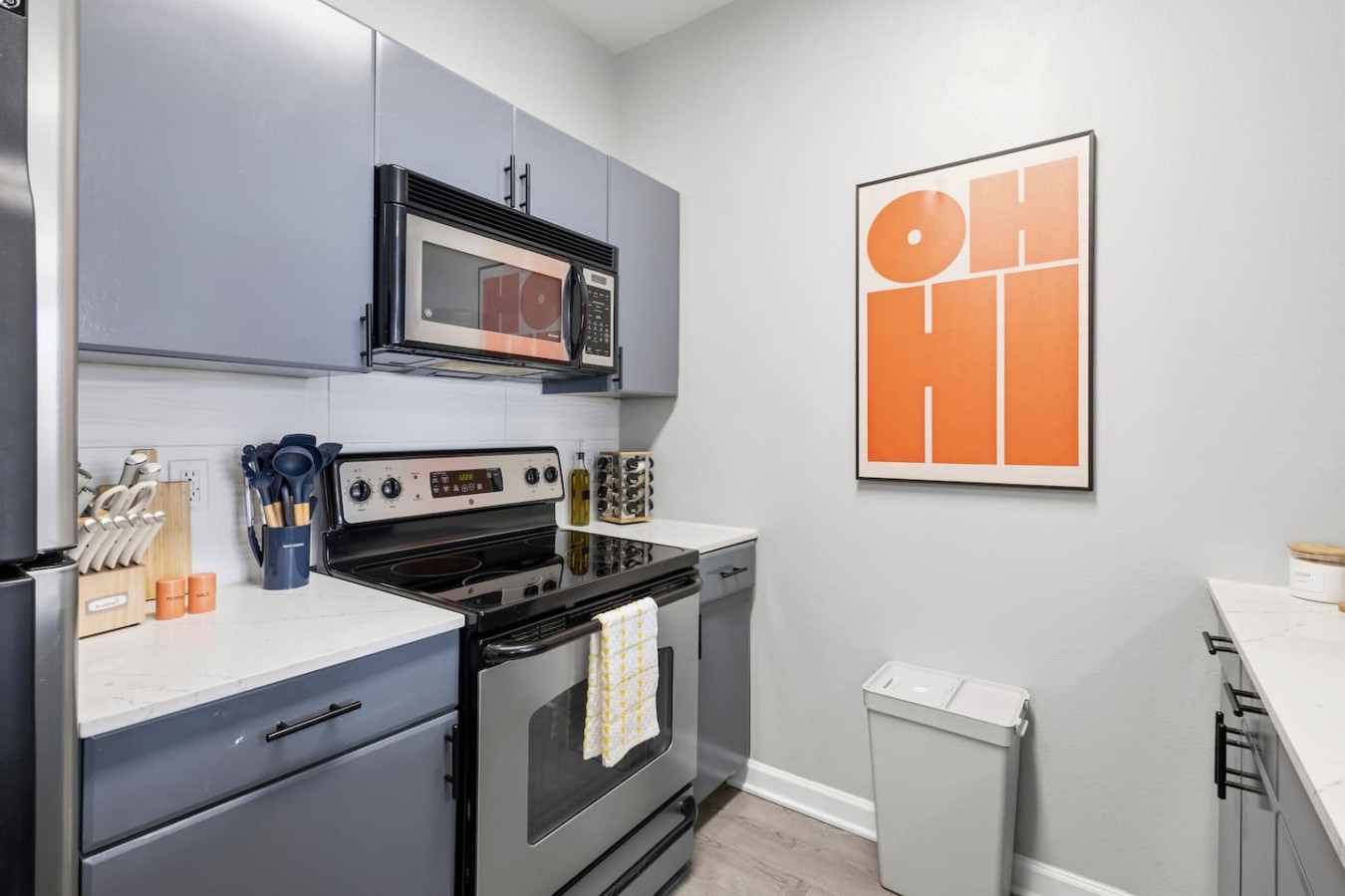 Kitchen essentials with stove, microwave, and cookware.