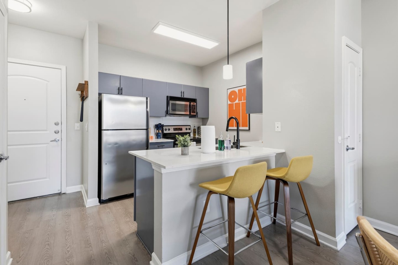 Modern kitchen with breakfast bar and stainless steel appliances.