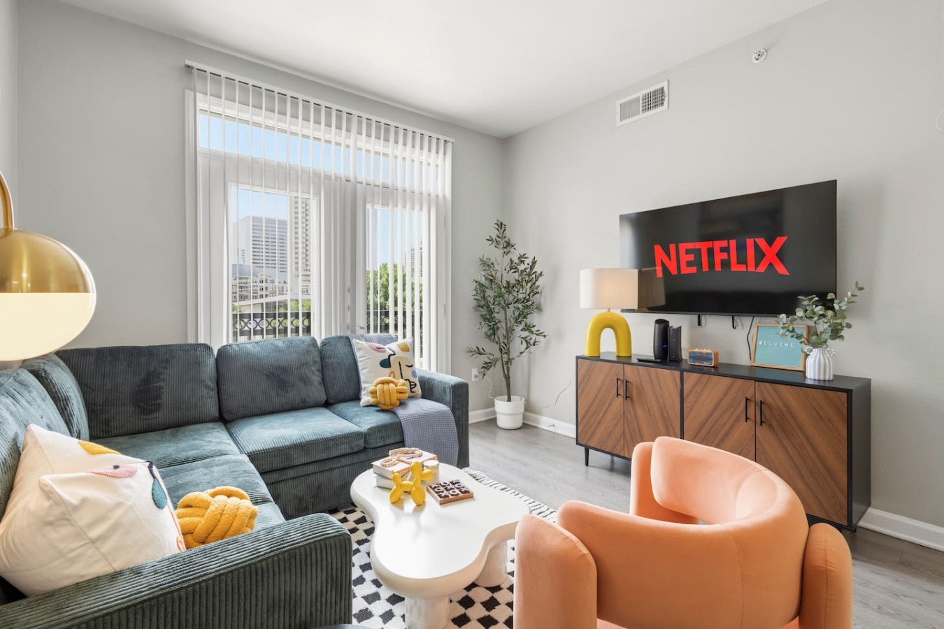 Bright living room with cozy seating, natural light, and a smart TV—perfect for relaxing after work, exploring Dallas, or enjoying a quiet night in.