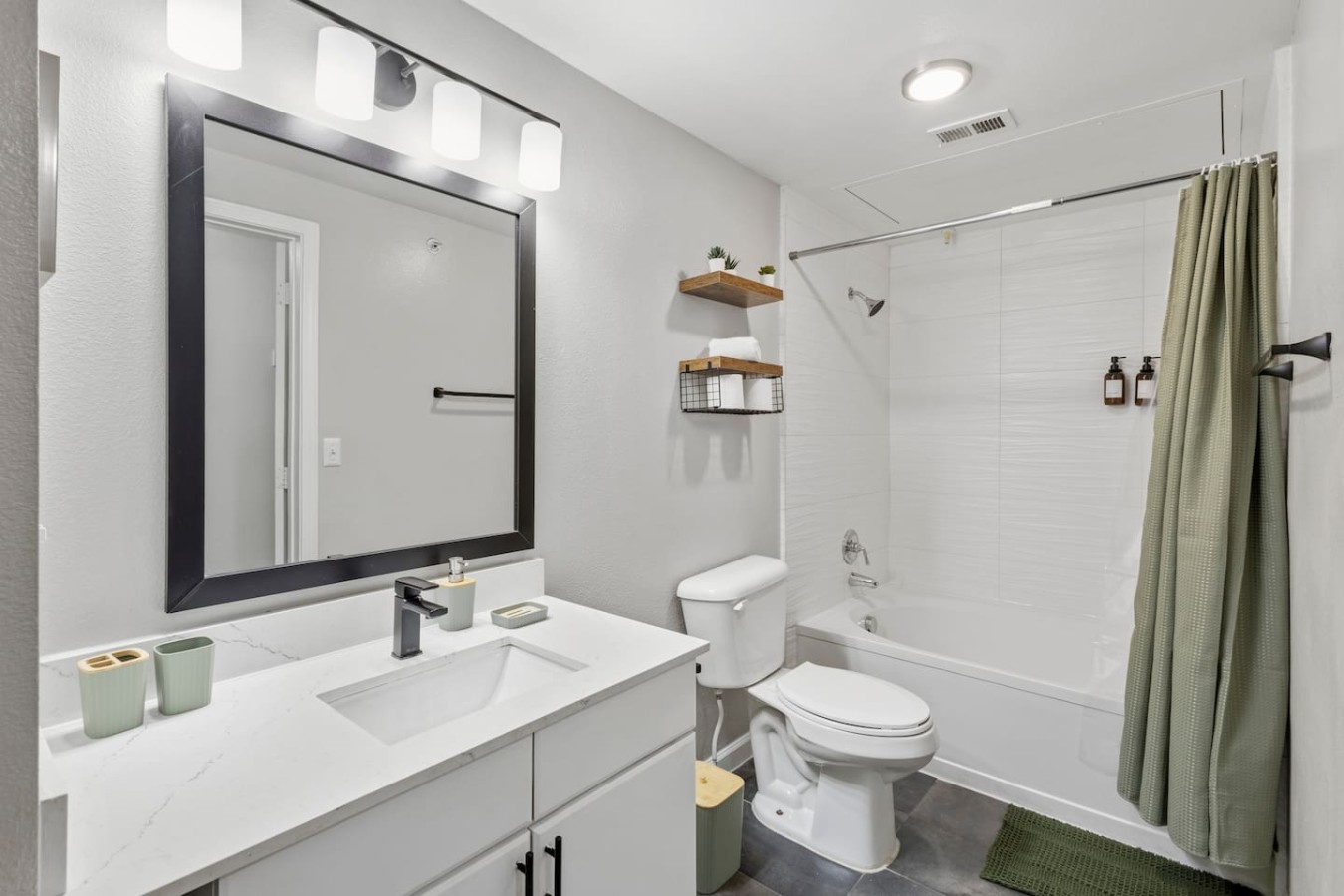 Clean bathroom with bright vanity, shower, and stocked essentials.