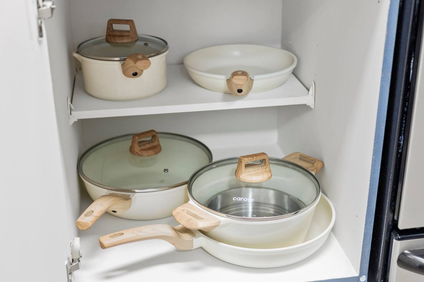 Cabinet with pots and pans ready for cooking meals.