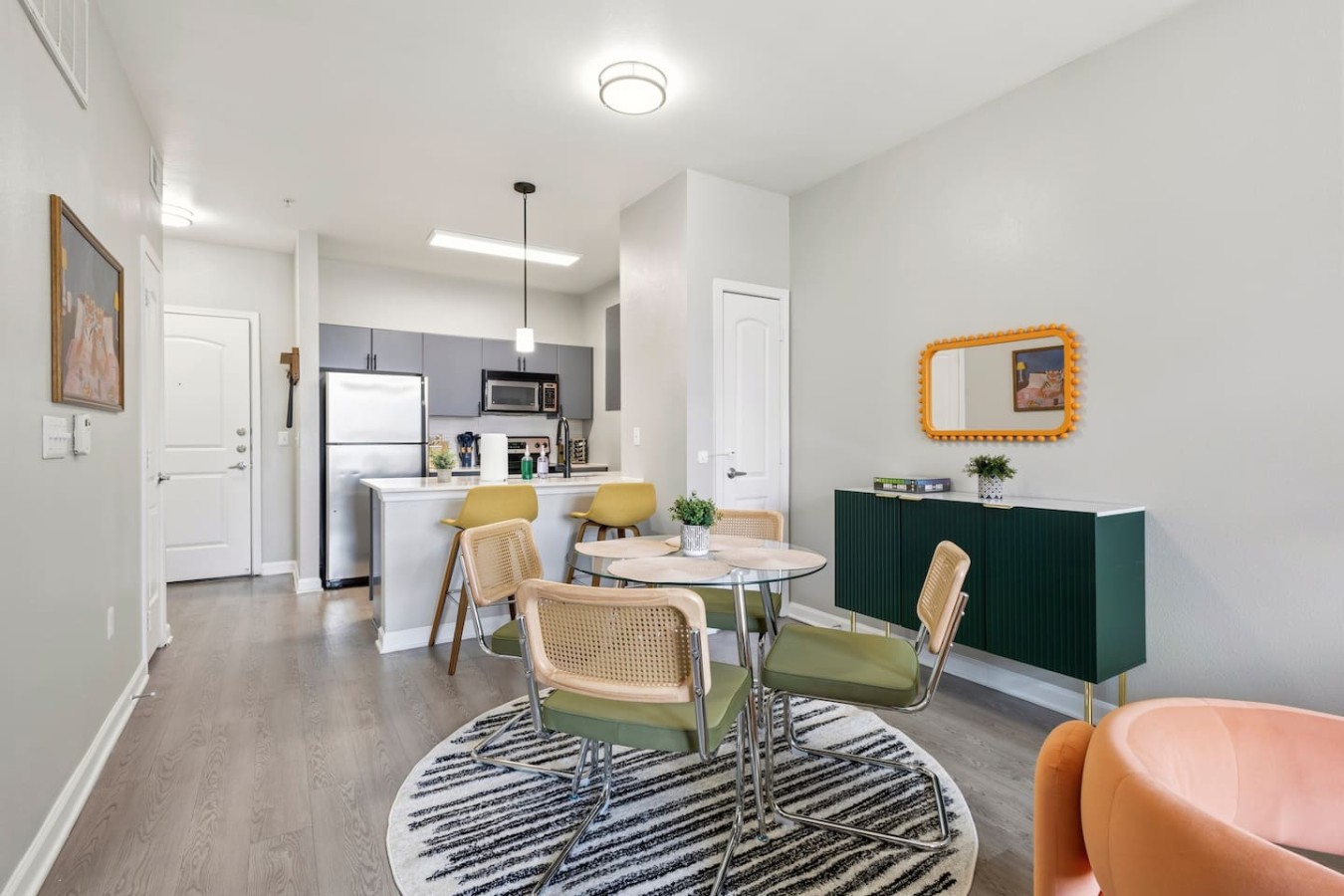 Open dining area with table, chairs, and view into kitchen.