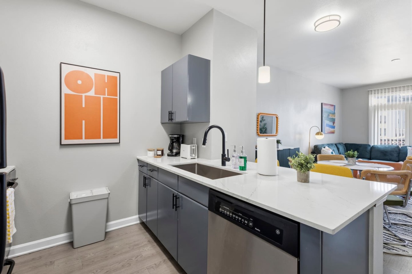 Kitchen with dishwasher, sink, and open view to living area.