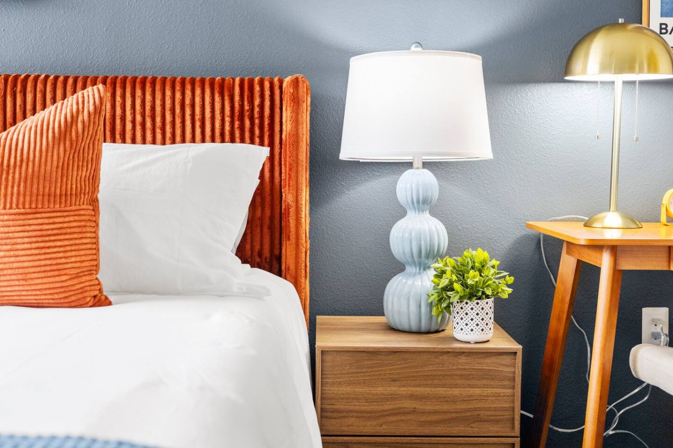 Bedside table with reading lamp and workspace nearby.