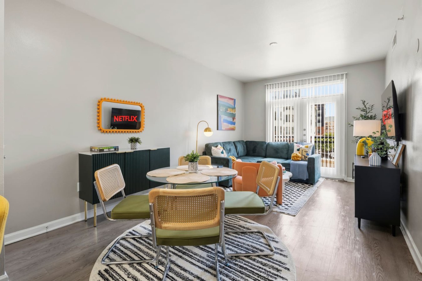 Bright open living and dining area with smart TV and balcony views.