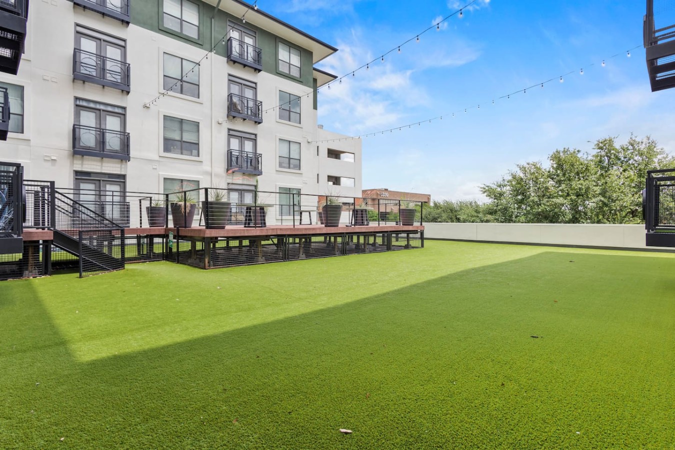 Shared outdoor deck with open green space, ideal for pets and relaxation.