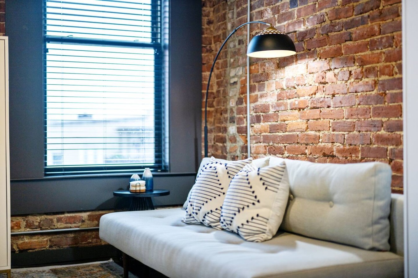 The living room’s plush seating beckons you to sink in and relax, surrounded by light and airy decor.
