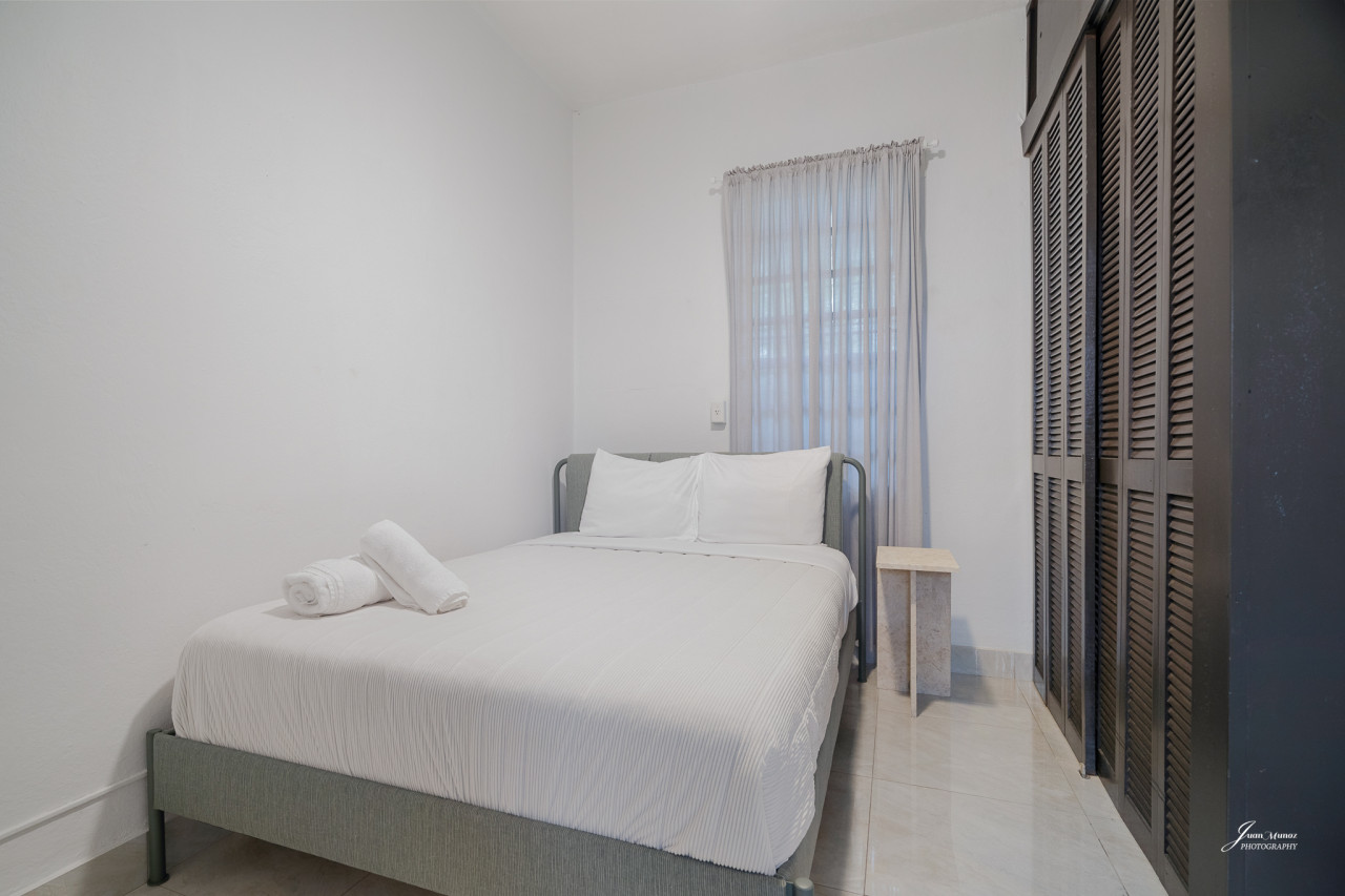 Bedroom with a white bed and a white towel on it — Villa Blanca | San Juan | La Plácita, Miramar