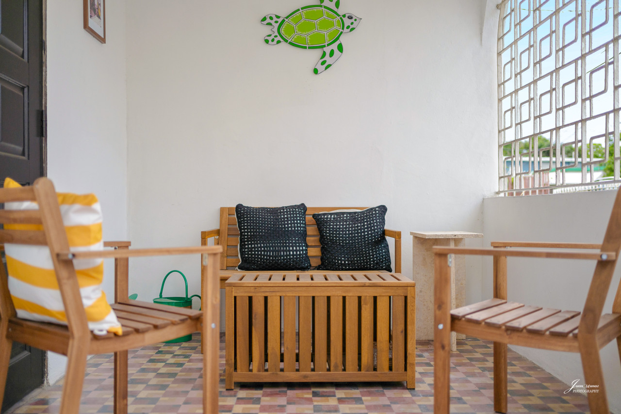 Wooden bench with two black pillows on it — Villa Blanca | San Juan | La Plácita, Miramar