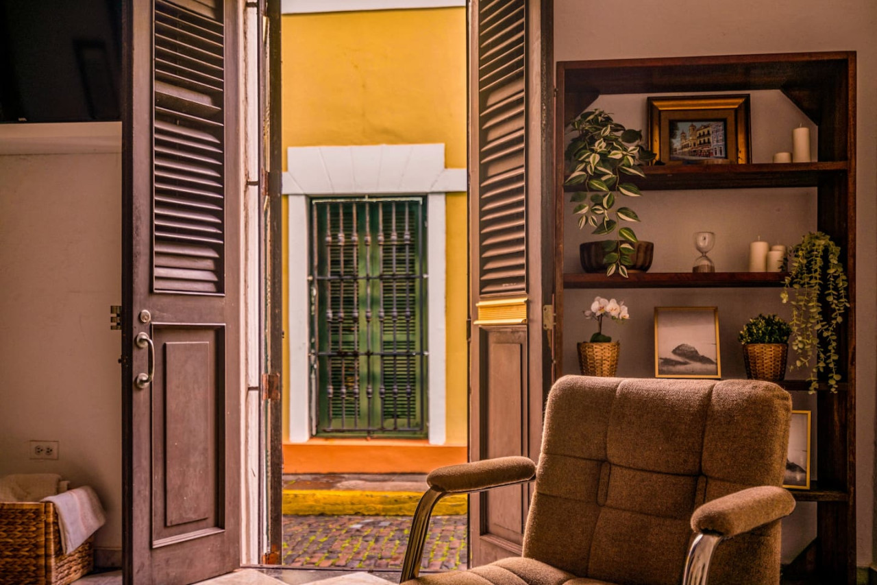 View of the street from the balcony of a yellow building — Ocean Breeze | Old San Juan | Spanish Style, Old San Juan